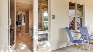 A hotel entrance with a glass door, a small seating area with chairs, and a number sign indicating room 1.