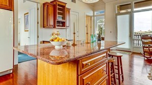 Una cocina amplia con una isla grande, armarios de madera y vistas al exterior.
