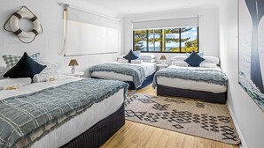 Camera da letto moderna con due letti, un'ampia finestra vista panoramica e una decorazione a galleggiante sul muro.