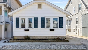A single-story house with a gabled roof, white siding, and dark green shutters. - 4BR Home w/ Rooftop Deck - 3 Block to Beach (Ventnor City)