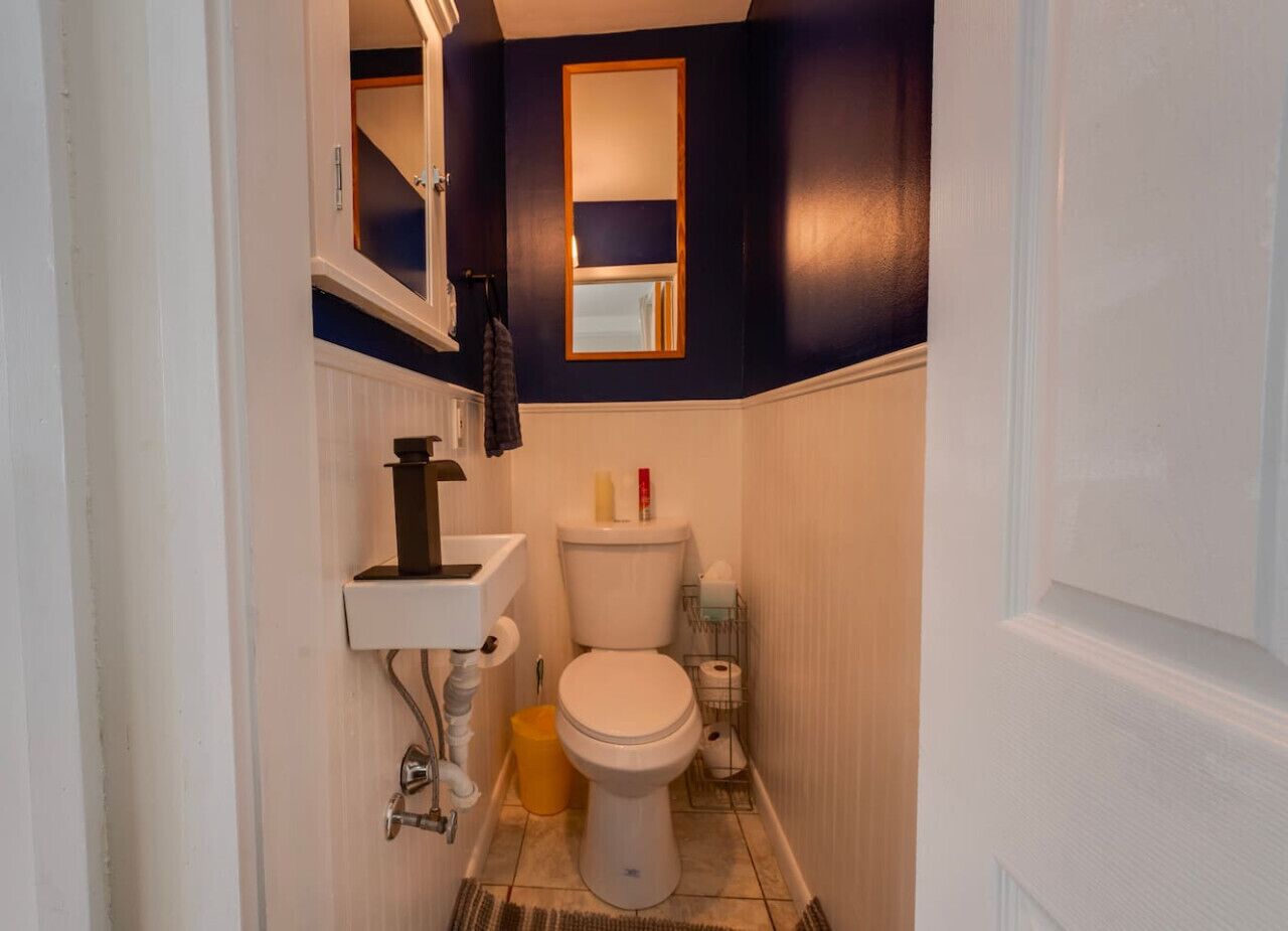 Un baño pequeño con inodoro, lavamanos y espejo.