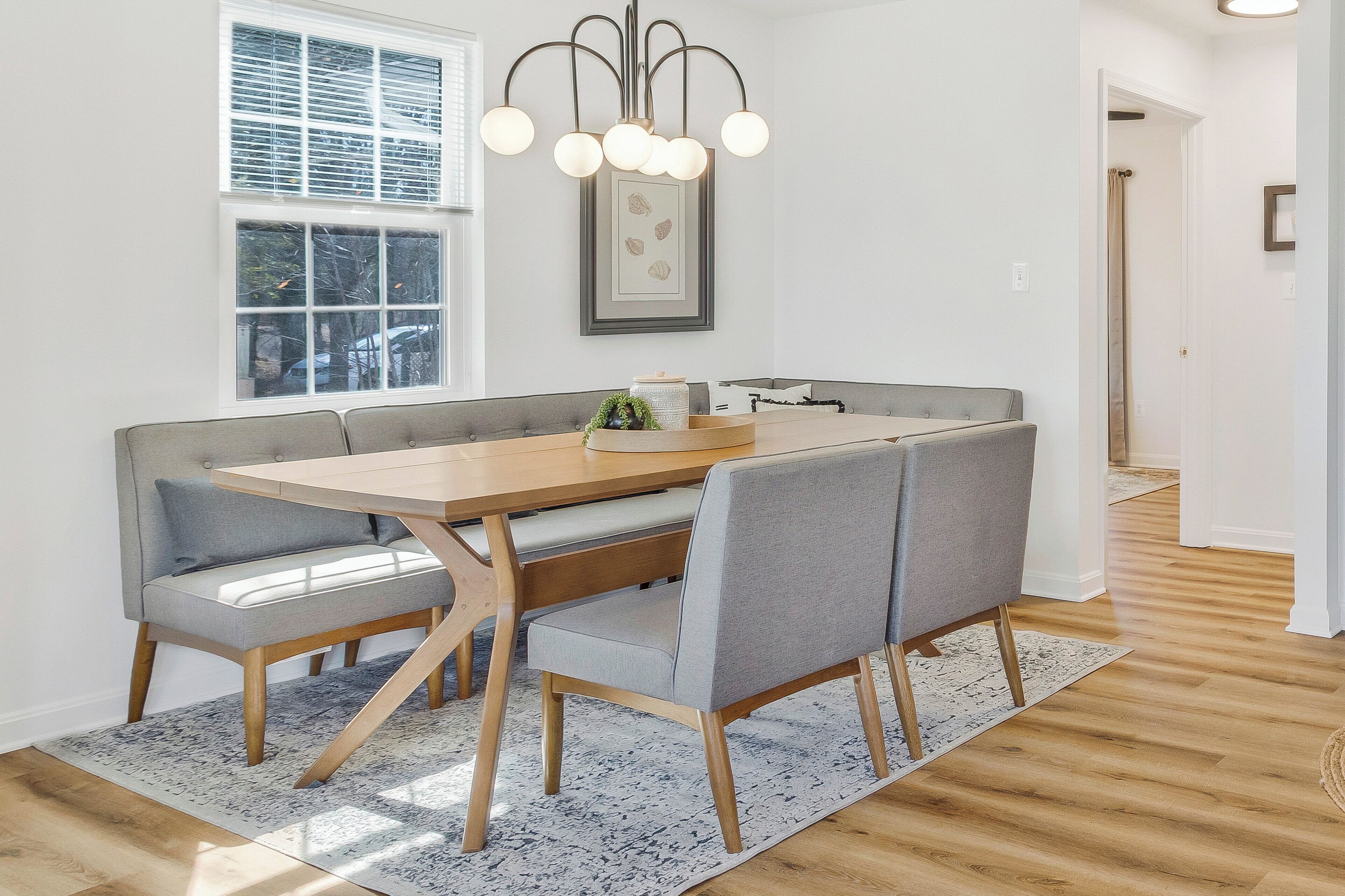 Een eetgedeelte met een houten tafel en grijze gestoffeerde banken.