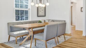 Een eetgedeelte met een houten tafel en grijze gestoffeerde banken.