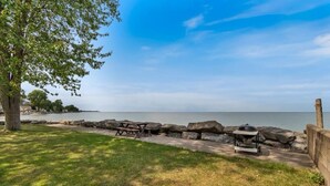 A picnic area with a grill and picnic table by a lake. - Cozy Lake house in Hilton with beach access. (Hilton)