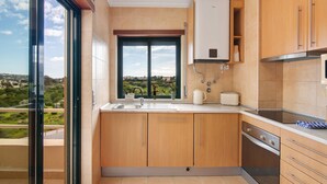 Een moderne keuken met een groot raam, een ingebouwde oven en uitzicht op het landschap.