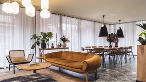 En moderne stue med sofa, sofabord og spiseplads.