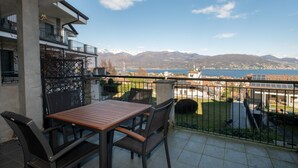 A balcony with a table and chairs, overlooking a lake and mountains. - Baveno View by Interhome (Baveno)