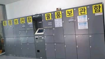 A row of grey lockers with yellow labels and a security keypad.