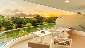 Ein Balkon mit Pool, einem Esstisch mit Stühlen und einer Badewanne.