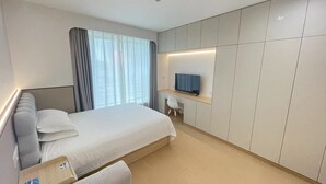 A modern hotel room with a large bed, a desk with a chair, a television, and a wardrobe. - 2mins walk to Metro station(3 lines), 10mins walk to theme park (Changning)