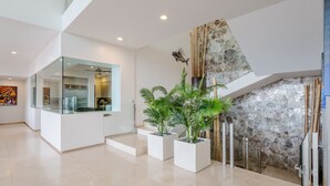 Um interior moderno com divisória de vidro, parede de pedra e plantas em vasos.