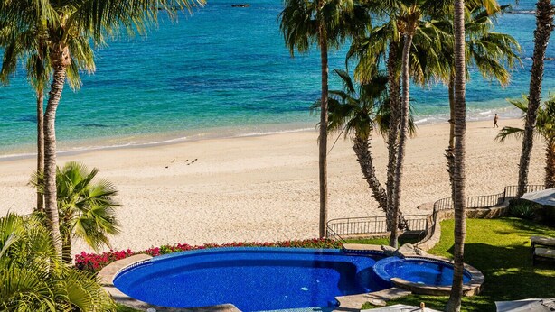 Un espace piscine offrant une vue sur la plage et l’océan.