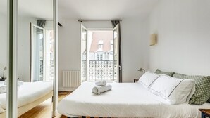 A bedroom with a bed, a window, and a view of a building outside. - The cellarman  Pathéon by Mon Mon Petit Faré (Paris)