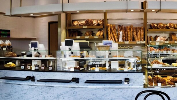 A bakery counter with various baked goods, a cash register, and a digital payment terminal. - The cellarman  Pathéon by Mon Mon Petit Faré (Paris)