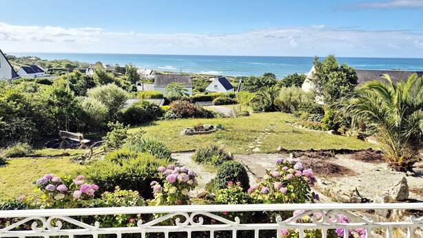 Une vue sur la côte, avec des maisons, un jardin et une clôture blanche.