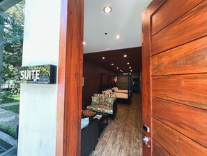 A wooden interior with a bed, a sofa, and a sign reading "SUITE". - Hotel Dumaguete (Dumaguete)