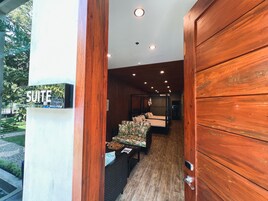 A wooden interior with a bed, a sofa, and a sign reading "SUITE".
