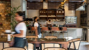 A restaurant interior with a brick wall, wooden ceiling, and a counter with a display case. - Hotel Dumaguete (Dumaguete)