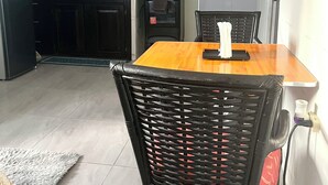 Une cuisine de taille réduite, équipée d’une cuisinière, d’un évier et d’un coin repas avec une table et des chaises.