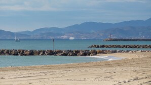 A beach with rocky breakwaters, calm sea, and distant mountains. - St Cyprien superb house residence with swimming pool (Saint-Cyprien)