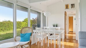 A bright room with large windows, a dining table, chairs, a sofa, and a potted plant. - Sea view, 200m to the beach, beautiful nature (Slagelse)