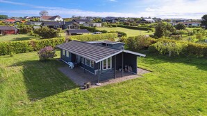 A modern house with a large patio, surrounded by a well-maintained lawn and garden. - Sea view, 200m to the beach, beautiful nature (Slagelse)