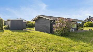 A residential property with a detached house, a garage, and a covered outdoor area.
