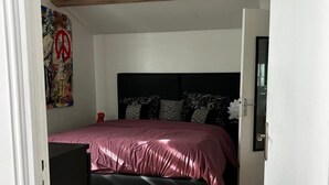 A bedroom with a bed, a ceiling fan, a wooden floor, and a door. - Le cabanon du Cannet.charming, fully-equipped two-room apartment close to amenities. (Le Cannet)