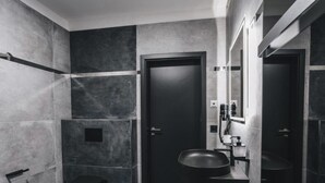 A modern bathroom with a toilet, sink, and mirror.