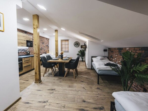 A compact living space with a kitchenette, a dining area, and a bed.