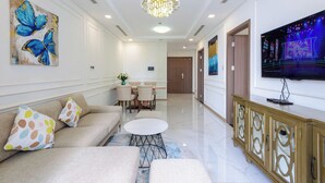 A modern living room with a sofa, coffee table, and a TV on a cabinet. - Sunwah Pearl Centre Point (Ho Chi Minh City)