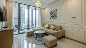 A modern living room with a sofa, ottoman, and coffee table, large windows with a city view, and a chandelier. - Sunwah Pearl Centre Point (Ho Chi Minh City)