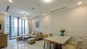 A spacious living area with a large dining table, comfortable seating, and a view of the city through large windows. - Sunwah Pearl Centre Point (Ho Chi Minh City)