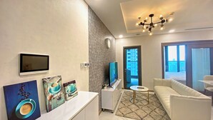 Una sala de estar moderna con un sofá blanco, una mesa de centro y obras de arte en la pared.