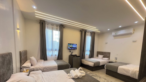 Een hotelkamer met twee bedden, een televisie en een airconditioning.
