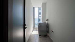 A narrow hallway with a view of a high-rise building through a large window. - DE LA SOL Centre Point By An Gia Hospitality (Ho Chi Minh City)