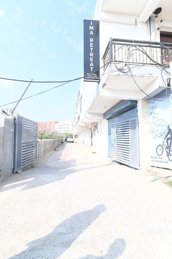A building with a sign reading "IMA RETREAT" and a bicycle mural on the wall. - Ima Retreat (New Delhi)