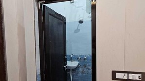 A bathroom with a sink, a shower, and a door. - Vinayak Guest House  (Faizabad)