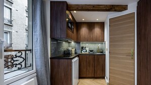 Een compacte keuken met houten kastjes, een ingebouwde magnetron en een klein aanrecht.
