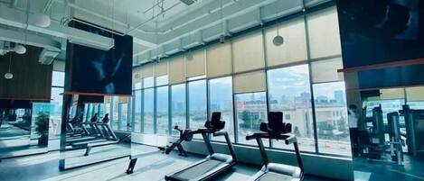 A gym with treadmills, exercise bikes, and weight machines.