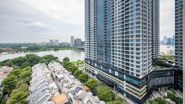 A high-rise building with a modern architectural design, surrounded by greenery and a river in the background. - OPAL SAIGON PEARL Premier Residence (Ho Chi Minh City)