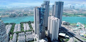 A high-rise building with multiple floors, surrounded by other buildings, near a body of water. - OPAL SAIGON PEARL Premier Residence By An Gia Hospitality (Ho Chi Minh City)