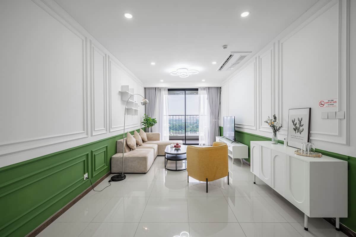 Una sala de estar moderna con sofá, sillón, mesa de centro y una consola blanca.