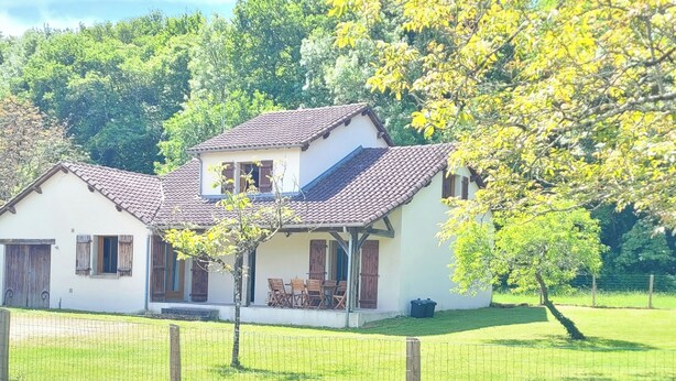 A two-story house with a tiled roof, a porch with chairs, and a fenced yard. - L'Étoile Normande - Country house (Bourgnac)