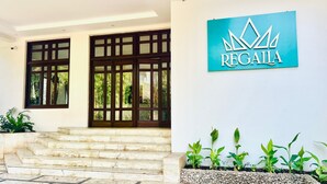 A building entrance with a sign reading "REGAIA" and a set of marble steps leading up to it. - The Regalia Goa (Alto de Porvorim)