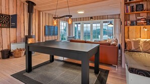 A cozy room with a wooden interior, a black table, and a sofa.