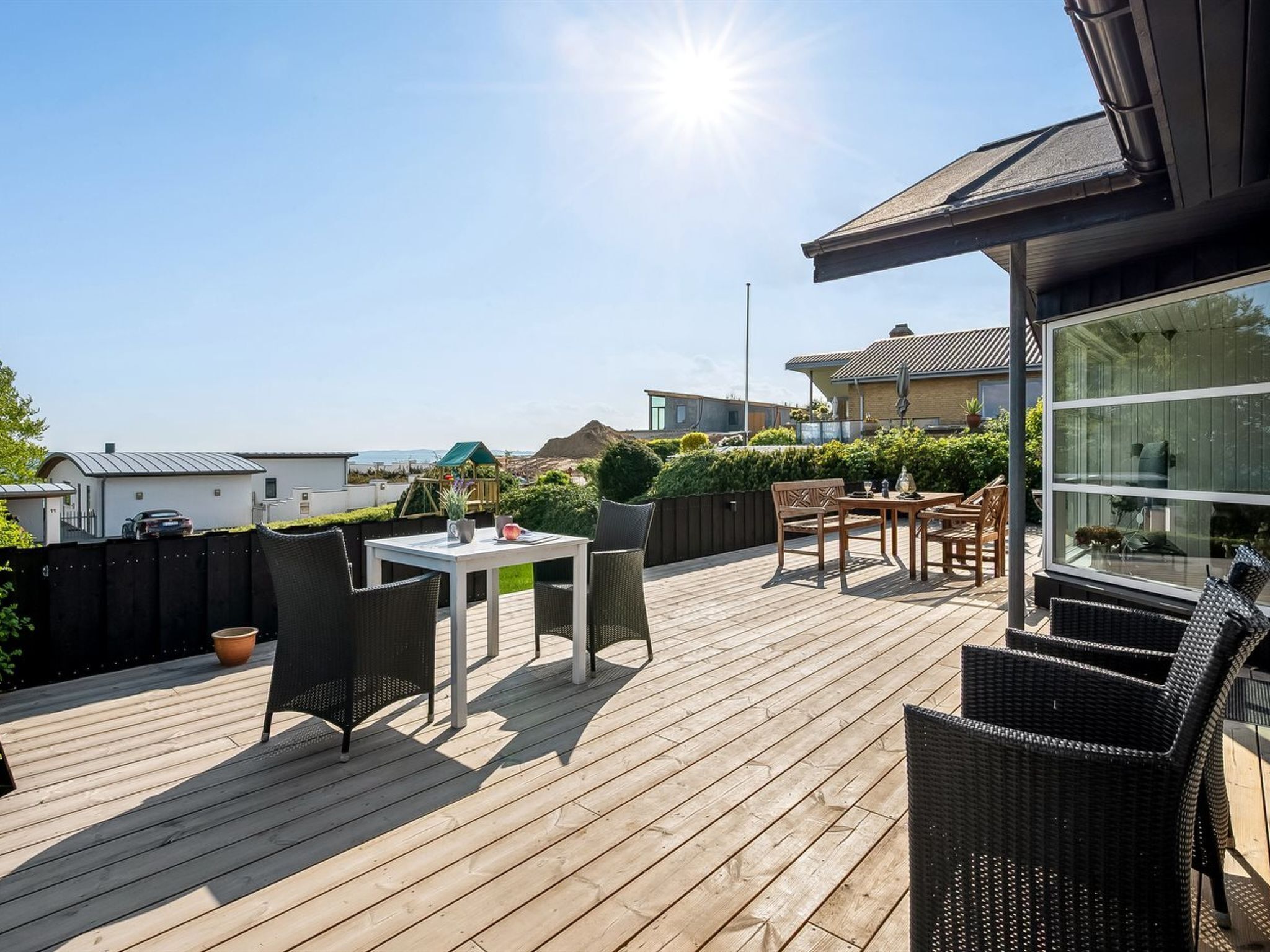 A wooden deck with outdoor furniture, a table, and chairs.