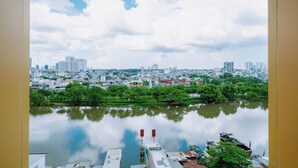 A cityscape with a river in the foreground, buildings in the background, and a clear sky. - DE LA SOL Premier Residence (Ho Chi Minh City)