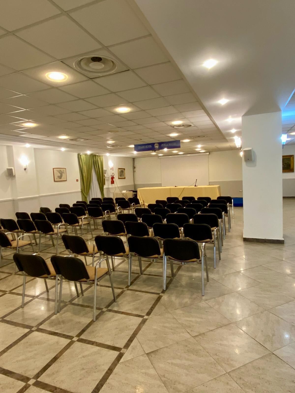 A conference room with rows of chairs, a podium, and a whiteboard.