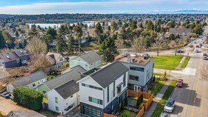 A residential area with modern houses, a road, and a lake in the background. - Ember & Glow Loft Retreat (Seattle)